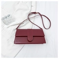 Deep red glossy leather flap bag shown on a minimalist white fabric and glass setup - Red