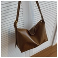 Detailed view of large brown hobo bag with wide strap and golden hardware buckle - Brown