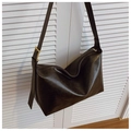 Close-up of deep brown tote bag featuring a glossy texture and golden square buckle - Coffee