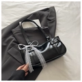 Détail du sac en cuir verni noir avec nœud en dentelle blanche et rivets argentés - Noir