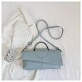 Détail du sac à bandoulière bleu clair avec texture lézard et poignée en métal demi-cercle - Bleu