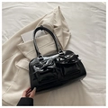 Dettaglio della borsa bowling nera lucida con fiocchi decorativi e fibbie metalliche - Nero