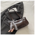 Détail du sac sous l'aisselle marron foncé brillant avec nœud en dentelle et rivets - Café