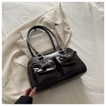 Detail of dark brown glossy shoulder bag with bow accents and double front pockets - Coffee