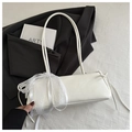 White rectangle shoulder bag with lace trim and ribbon detail in a chic setting - White