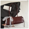 Dark red patent leather underarm bag featuring a delicate white lace bow detail - Red