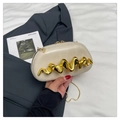 Detalle de bolso de mano crema con un distintivo adorno metálico dorado ondulado - Blanco Roto