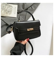 Elegante borsa a tracolla nera minimalista con fibbia dorata su sfondo di un libro - Nero