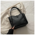 Macro view of black leather bucket bag with stitch detail and snap closure for daily commute - With Pendant / Black