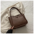 Detailed close-up of brown leather bucket bag with retro button and slim shoulder straps - With Pendant / Coffee