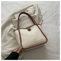 Close-up of cream bucket bag showing contrast brown trim and premium leather texture - With Pendant / White