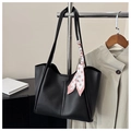 Detail of black matte leather tote bag with vertical stitching and pink polka dot scarf - Black