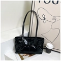 Detail of black glossy patent leather shoulder bag with pleated design and metal buckle - Black