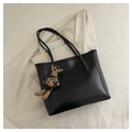 Detail of black faux leather tote bag with rabbit charm on a beige blazer background - With Pendant / Black