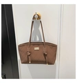 Detail einer dunkelbraunen gesteppten Tragetasche mit goldener Plakette und Knotengriffen - Stil 2 Braun