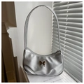 Macro detail of a metallic silver hobo bag featuring a 3D metal butterfly emblem - Silver
