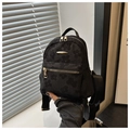 Detail eines schwarzen Mini-Rucksacks mit Blumenmuster, Gold-Reißverschlüssen und Tragegriff - Schwarz