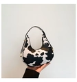 Détail du sac demi-lune avec motif vache et boucles métalliques dorées sur le côté - Imprimé vache