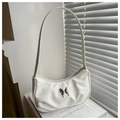 Detail shot of a white half-moon underarm bag with a silver butterfly metal buckle - White