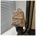 Detail eines hellbraunen Mini-Rucksacks mit Gänseblümchen-Druck und goldenen Metallteilen - Khaki