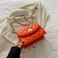 Classic bright orange quilted flap crossbody bag with gold chain strap on tweed blazer - Orange
