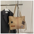 Detalle de bolso tote caqui con parches de moda y borlas en un perchero de metal - Caqui Oscuro