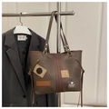 Detalle del bolso tote marrón oscuro con rayas rojas y parches de moda elegantes - café