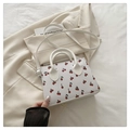Detalle del bolso blanco con estampado de cerezas sobre una elegante chaqueta - Blanco