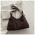 Detail of dark brown suede shoulder bag with adjustable strap over white corduroy - Coffee