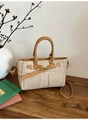 Detail der beigen Stoffhandtasche mit braunem Lederriemen und goldener Metallschnalle - Dunkelkhaki
