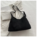 Detail of black suede shoulder bag featuring vertical seam stitching and curved silhouette - Black