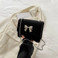 Mini black suede crossbody bag with wavy flap and silver bow clasp on chain strap - Black