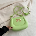 Elegante hellgrüne PU-Leder Schultertasche mit goldener Schleife auf beigem Blazer - Grün