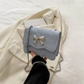 Light blue glossy mini crossbody bag with silver butterfly buckle and chain strap - Blue