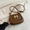 Dark brown leather shoulder bag featuring a decorative gold bow and elegant knotted straps - Brown