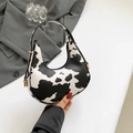 Stylish black and white cow print half-moon underarm bag with gold zipper and hardware - Cow Style