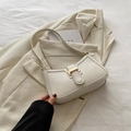 Bolso medialuna blanco minimalista con hebilla dorada sobre blazer blanco - Blanco
