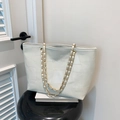 Dettaglio della borsa tote bianco crema con cuciture geometriche e catena oro - Bianco