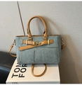 Details der grauen Canvas-Tasche mit braunem Lederbesatz und goldener Metallschnalle - Blau und Braun