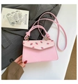 Detail of pink handbag with strawberry print cover and a unique knotted top handle design - Strawberry Print / Pink