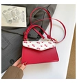 Detail of red small square bag featuring cherry print flap and knotted shoulder strap - Cherry Print / Red