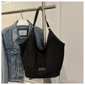 Détail d'un sac seau noir mat avec un petit emblème et des finitions en cuir élégantes - Noir