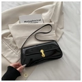 Black patent leather underarm bag with gold U-shaped buckle on beige blazer - Black