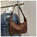 Detail der dunkelbraunen Wildleder-Hobo-Tasche mit vertikalen Nähten und verstellbarem Riemen - Braun
