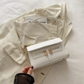 Elegant white vintage shoulder bag with dual zippers and gold lock on white blazer background - White
