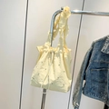 Bolso saco color crema con cordón, correa de hombro con volantes y tachuelas - Amarillo