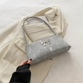 Chic grey marble texture shoulder bag with a silver metal bow accent on light blazer - Silver