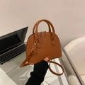 Detail view of brown shell bag featuring embossed snakeskin texture and gold hardware - Brown