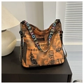 Detail der orangefarbenen Canvas-Tasche mit schwarzem Zeitungsdruck und bunten LOVE-Gurt - Braun