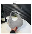 Detail shot of the grey crescent bag featuring crocodile embossed texture and gold zipper - Crocodile / Light Gray